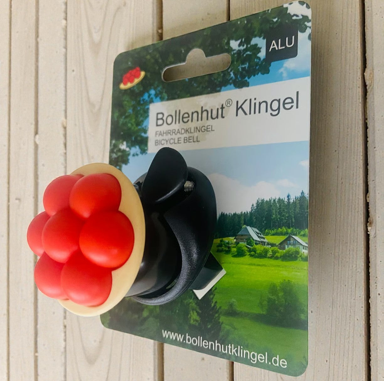 Fahrradklingel aus Aluminium mit einem Bollenhut und roten Bollen