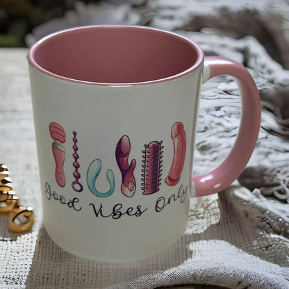 Weiße Keramiktasse mit der Aufschrift "good vibes only" und bunten Vibrator-Illustrationen, Innenseite und Henkel in rosé